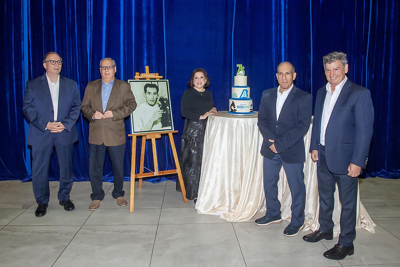Los hermanos Bueso Hernández, junto a la foto de su padre y el pastel del cumpleaños 75 de LBA.