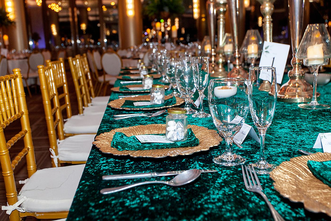 En el salón se dispusieron mesas estilo imperial con sillas Tiffany doradas y mantelería en terciopelo en tono verde esmeralda