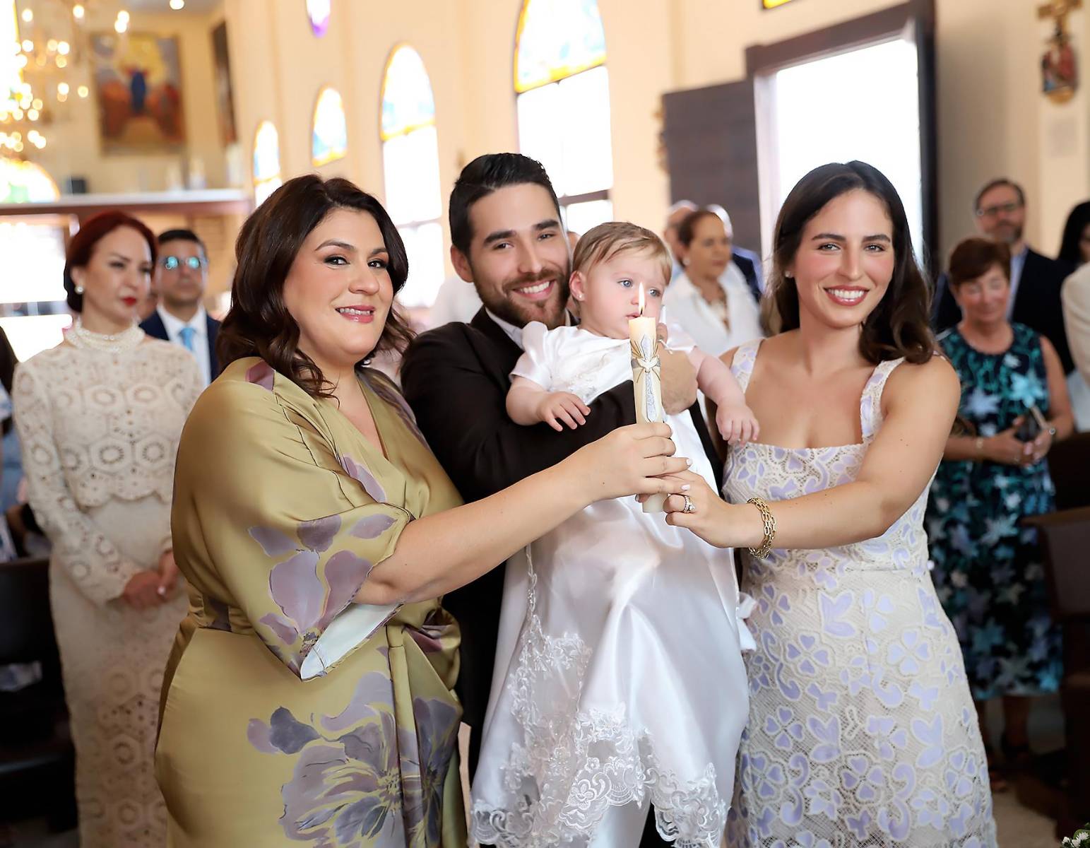 Con la llama encendida, los padrinos simboliza la luz de Cristo que guiará la vida de su ahijada.