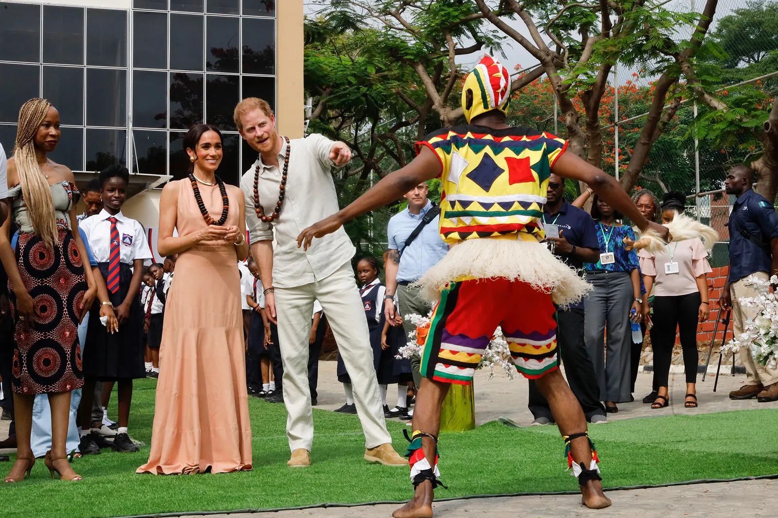 En su primer acto, los duques de Sussex visitaron una escuela para abordar temas de salud mental. Para ello, Meghan Markle optó un vestido largo en color nude hasta los tobillos, realizado en seda, que dejaba al descubierto su espalda. Se trata del modelo Windsor-Rubor, de la firma californiana Heidi Merrick,