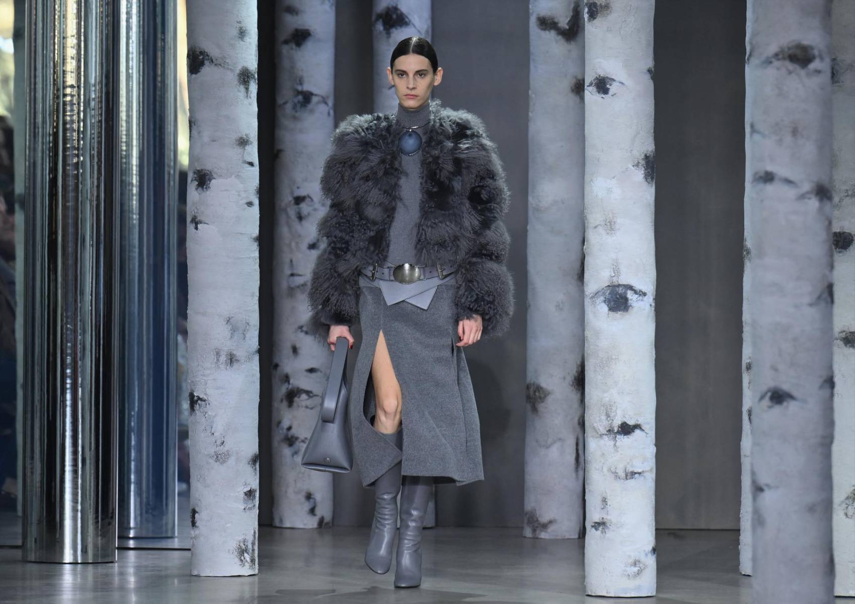 La mujer de Michael Kors enfrenta el próximo otoño-invierno con prendas prácticas, cómodas y elegantes en las que predominan los tonos marrón, azul marino y gris, así como accesorios de cuero que van desde cinturones XL y botas altas hasta bolsos de flecos.