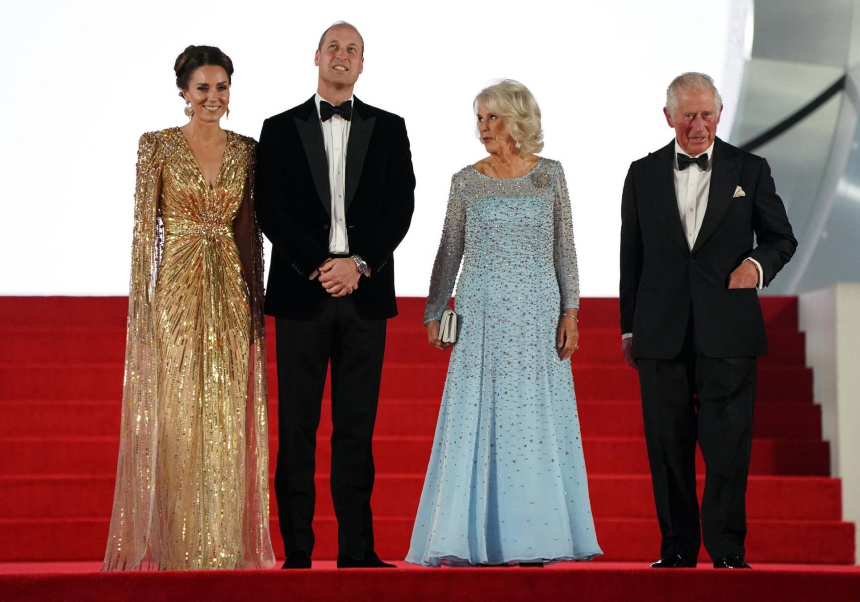 Desde la muerte de Isabel II, Camila ha trabajado en mejorar su imagen y su presencia en eventos comenzó a hacerse más frecuente. En la imagen en el estreno de <i>James Bond No Time To Die</i> en 2021 junto a los príncipes de Gales y su esposo, Carlos III