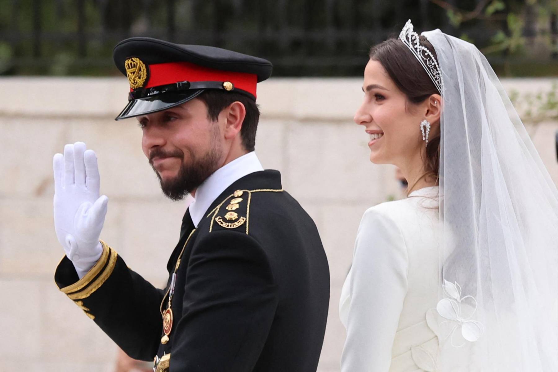 Los recién casados saludan al pueblo que los aguardaba en las calles de Amán (Photo by Khalil MAZRAAWI / AFP)