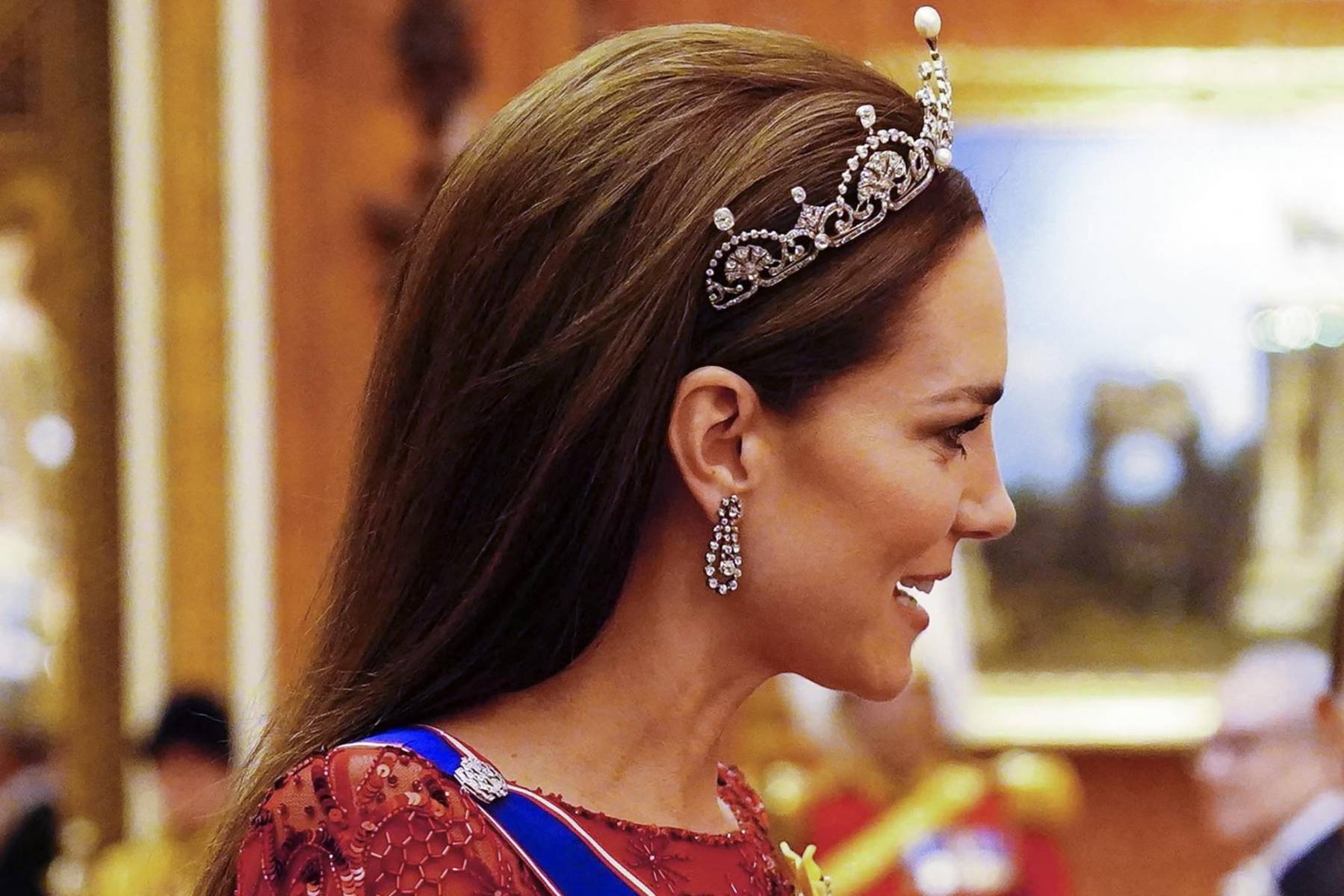 La princesa de Gales completó su look con pendientes de diamantes y la tiara Flor de Loto, que perteneció a la princesa Margarita. La exclusiva pieza, conocida también como tiara de Papiro de la Reina Madre, fue elaborada con diamantes en forma de abanico coronados por arcos de brillantes flotantes.
