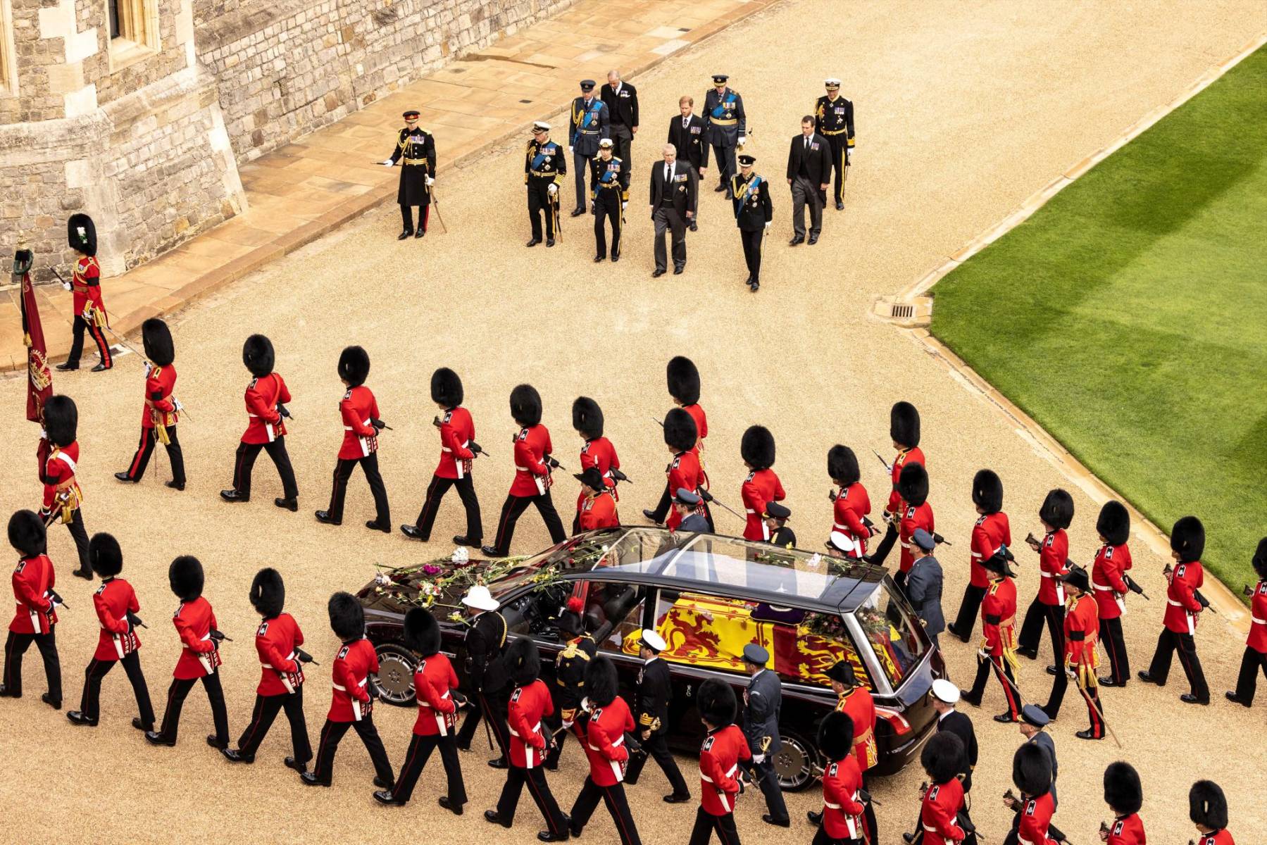 Miembros de la familia real se detienen con el rey Carlos III de Gran Bretaña mientras los granaderos de la Guardia escoltan el ataúd rumbo al castillo de Windsor. (Photo by Humphrey Nemar / POOL / AFP)
