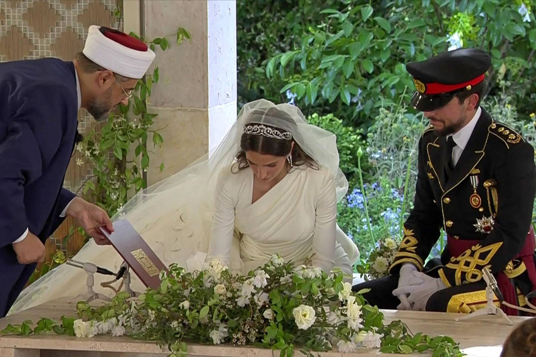 El príncipe Hussein y Rajwa al-Seif firman los documentos que certifican su unión mantrimonial, realizada en el Zahran Palace, donde también se casaron el rey Abdullah II y Rania (Photo by Jordanian Royal Palace / AFP) 