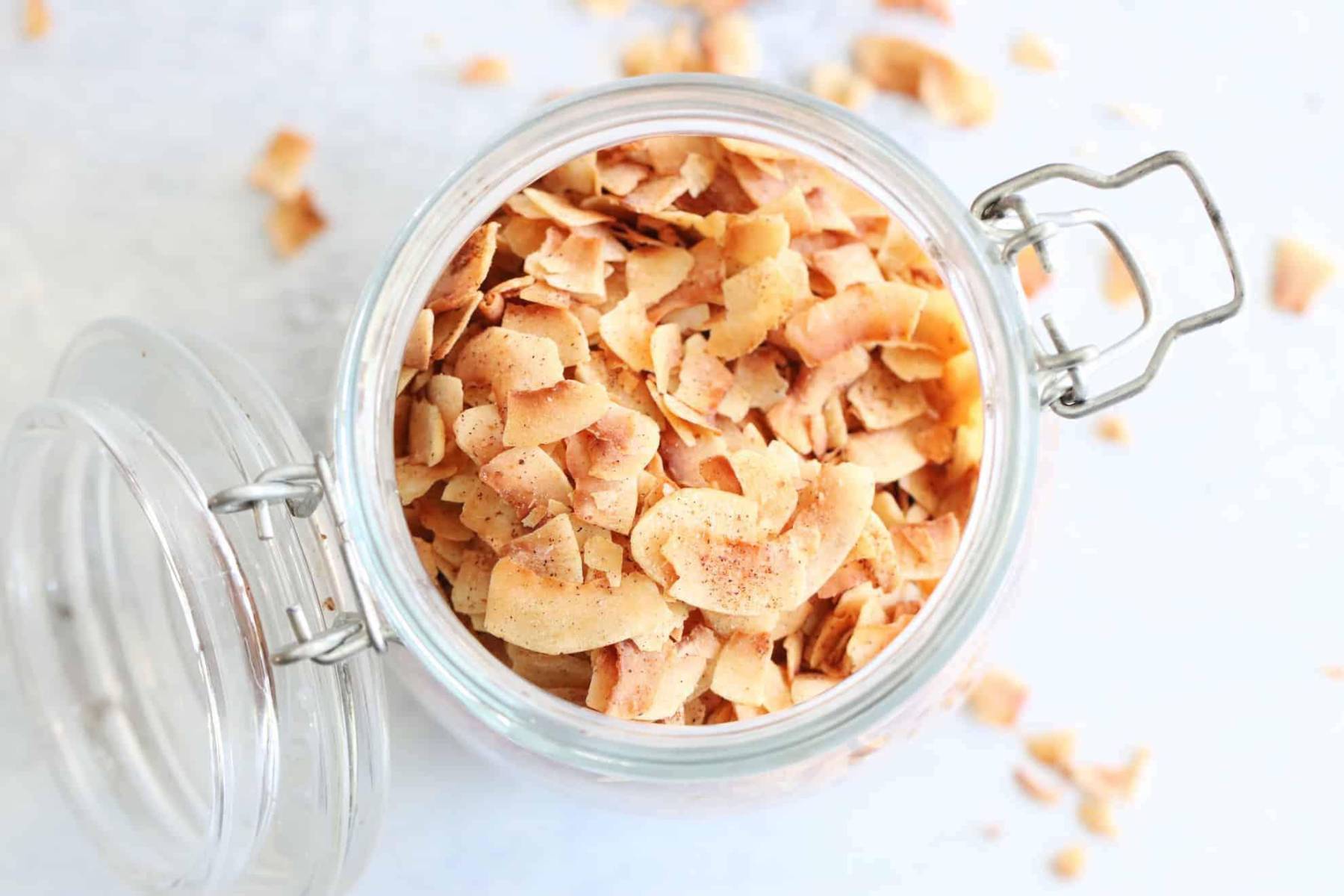 Para unas chips dulces, corta láminas finas de coco y hornéalas a 320°F de 15 a 20 minutos, hasta que doren y endurezcan. Puedes espolvorear canela o cacao, y esta fruta te aportará fibra y grasas saludables.