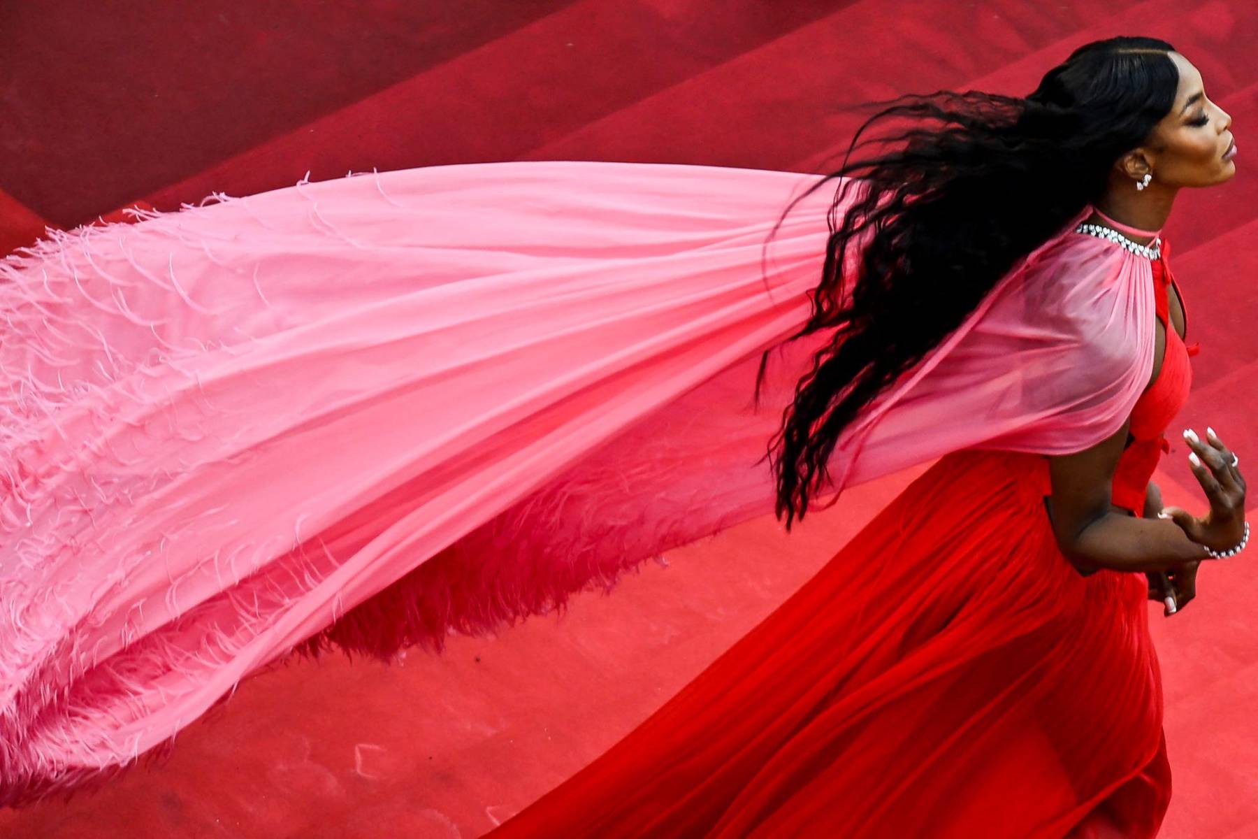 Naomi Campbell radiante con un diseño de capa con aplicaciones de plumas by Valentino