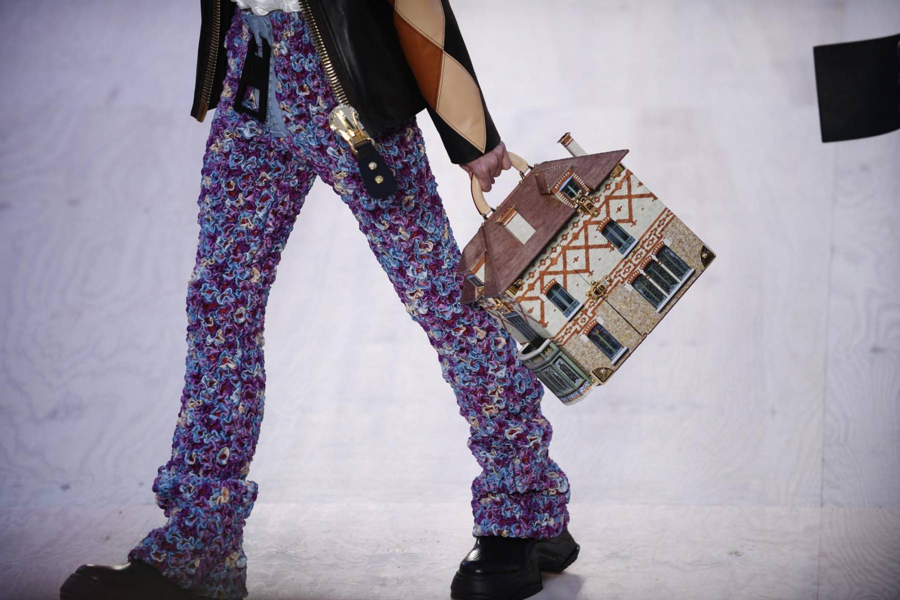 El pantalón viene ajustado, grabado y estampado con flores, en una mezcolanza de colores y texturas habitual de la marca. Se puede llevar con una cazadora abombada o un impermeable largo.