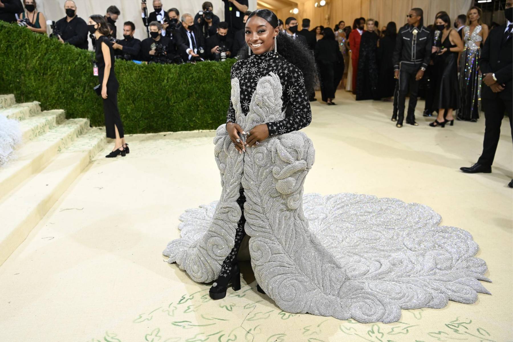 Simone Biles.Icono deportivo y símbolo de fuerza femenina. En la Met, Simone representa la gracia en movimiento, mostrando que la alta costura también puede ser atlética y poderosa. 