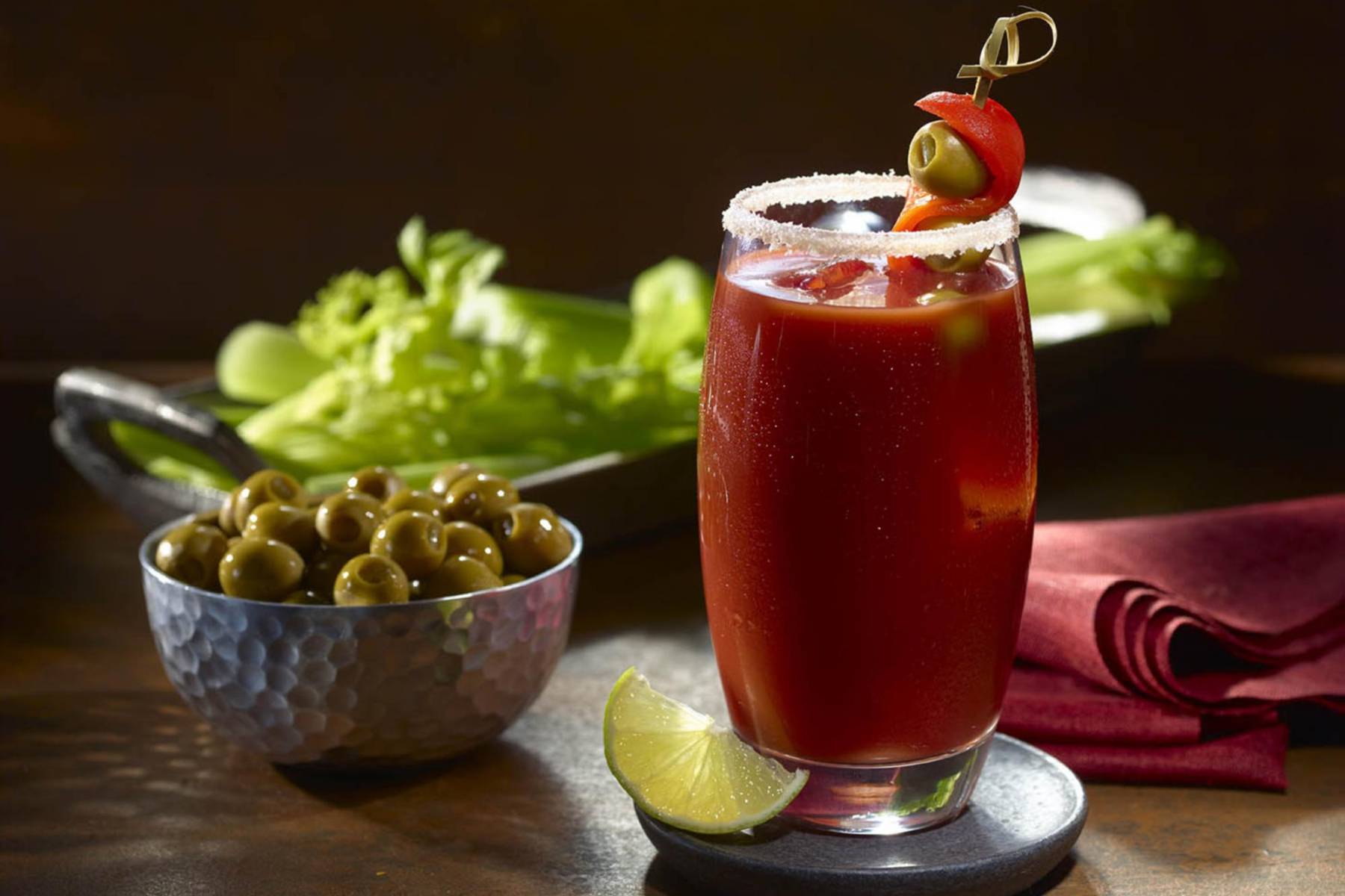 <b>Bloody Mary:</b>De un color tan intenso como su historia, el Bloody Mary debe su nombre a “María la sanguinaria”, la reina María I de Inglaterra, famosa por sus sangrientas persecuciones en el siglo XVI. Fue en los años 20 cuando el barman Fernand Petiot creó esta icónica bebida en el Nueva York de París, combinando vodka (45 ml), zumo de tomate (90 ml), unas gotas de salsa inglesa, sal, pimienta negra, un chorrito de jugo de limón y un toque de salsa Tabasco. Para prepararlo, simplemente mezcla todos los ingredientes en un vaso con hielo y remueve bien. Perfecto para darle un twist sofisticado a tus días de verano.