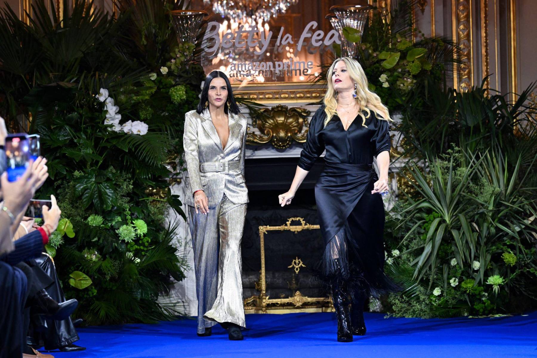 Abrieron y cerraron el desfile las actrices Natalia Ramírez, con traje chaqueta, y Lorna Cepeda, con un vestido negro de satén y botas brillantes, que encarnan respectivamente a Marcela y Patricia, también dos personajes principales de “Yo soy Betty, la fea”. 