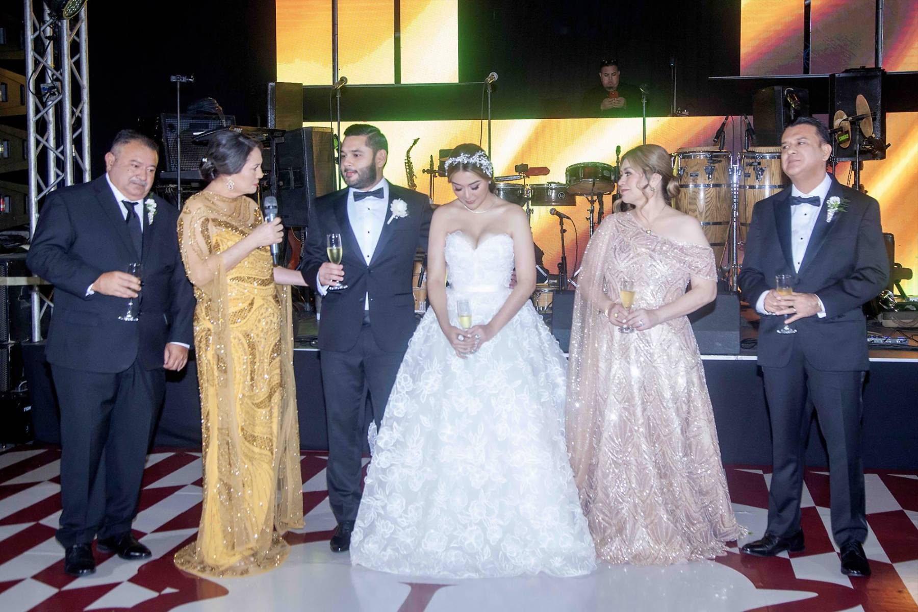 Los padres al momento de ofrecer un brindis por la felicidad de sus hijos.