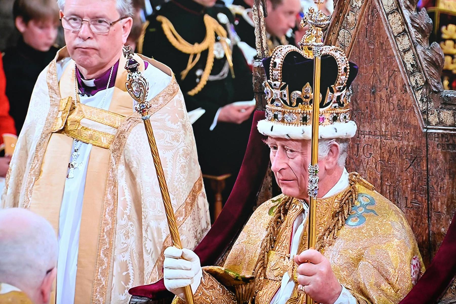<b>Carlos III</b> sentado en el trono como <b>Rey de Inglaterra</b> y del <b>Reino de Escocia</b> luego de haber recibido la corona, el brazalete de la sinceridad, la espada, la estola