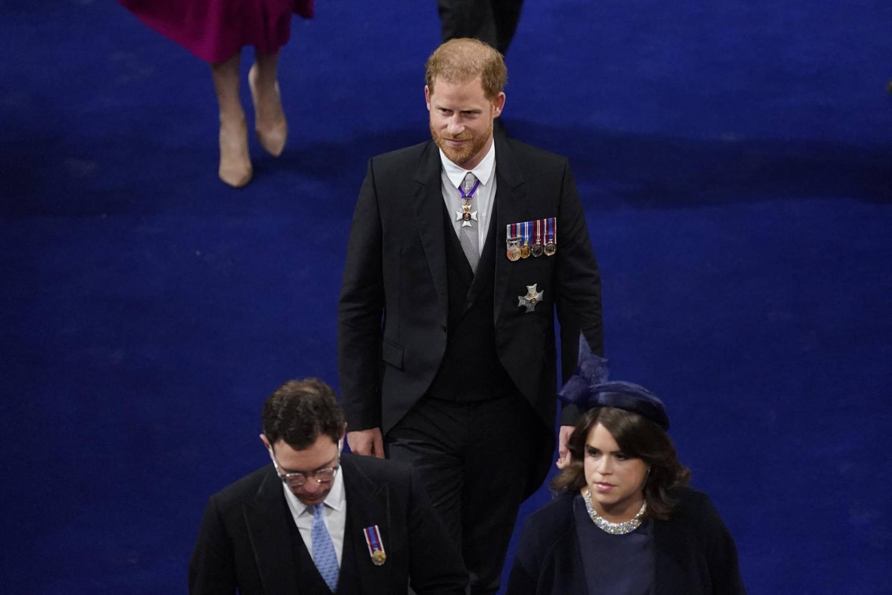 Sonriente, sin su uniforme militar y acompañado por sus primos, el príncipe Harry llegó a la abadía, donde todos los ojos estaban puestos en él.