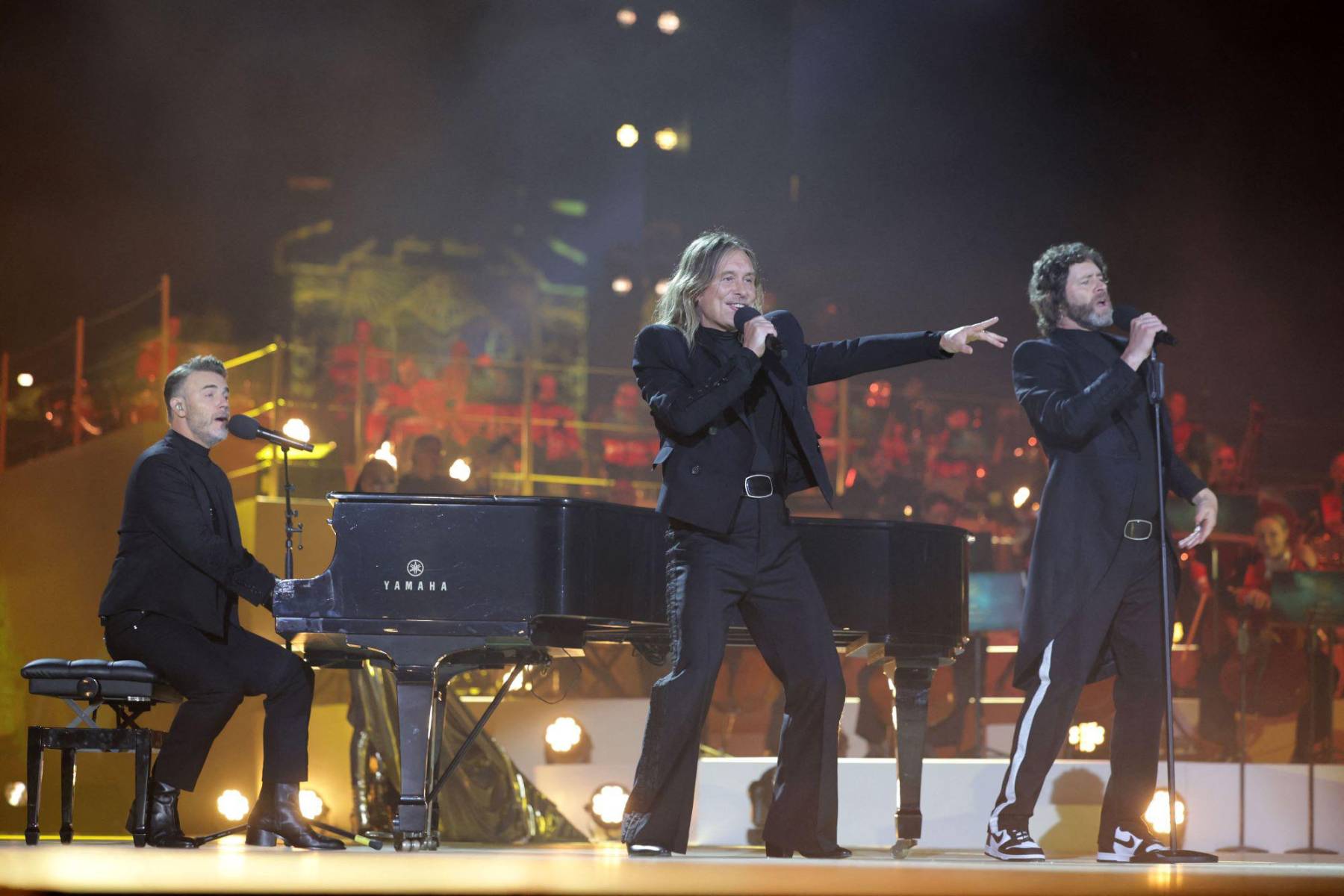 Gary Barlow, Howard Donald y Mark Owen de Take That durante el concierto