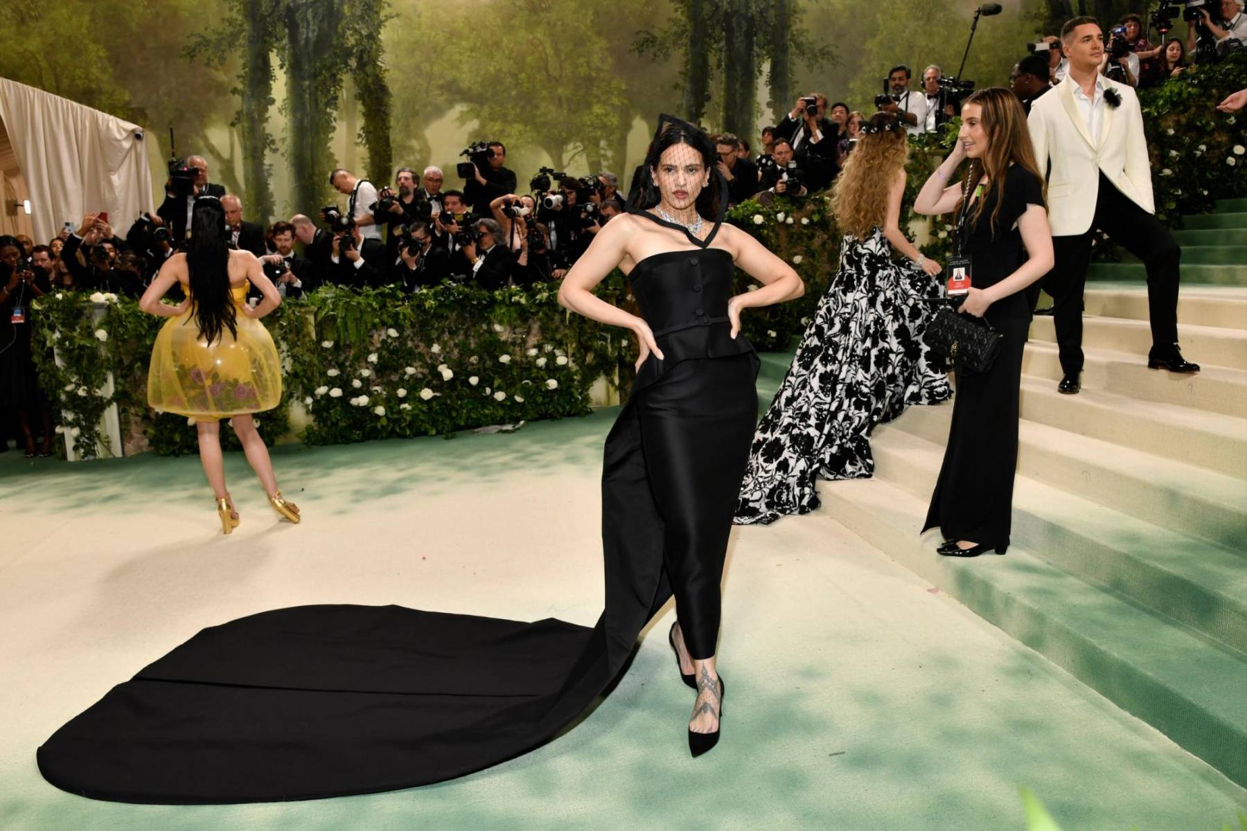 Como una previa al anuncio oficial de su fichaje, la cantante española Rosalía lució espectacular en la reciente edición de la MET Gala, personificando a Lady Dior a los ojos de Maria Grazia Chiuri, con un vestido strapless ajustado de larga capa y tocado de red que complementó con stilettos. 