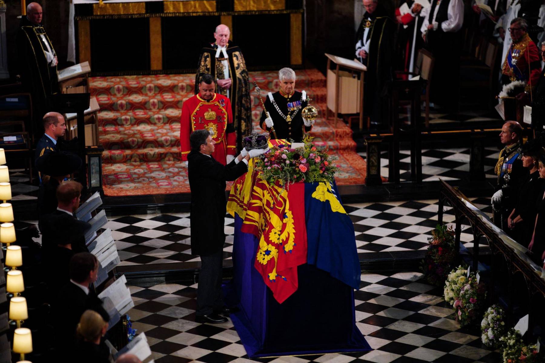 Miembros de la familia real observan el momento en que la corona es retirada del ataúd de Isabel II, quien fue monarca del Reino Unido desde su ascenso al trono en 1952 hasta su muerte (Photo by Ben Birchall / POOL / AFP)