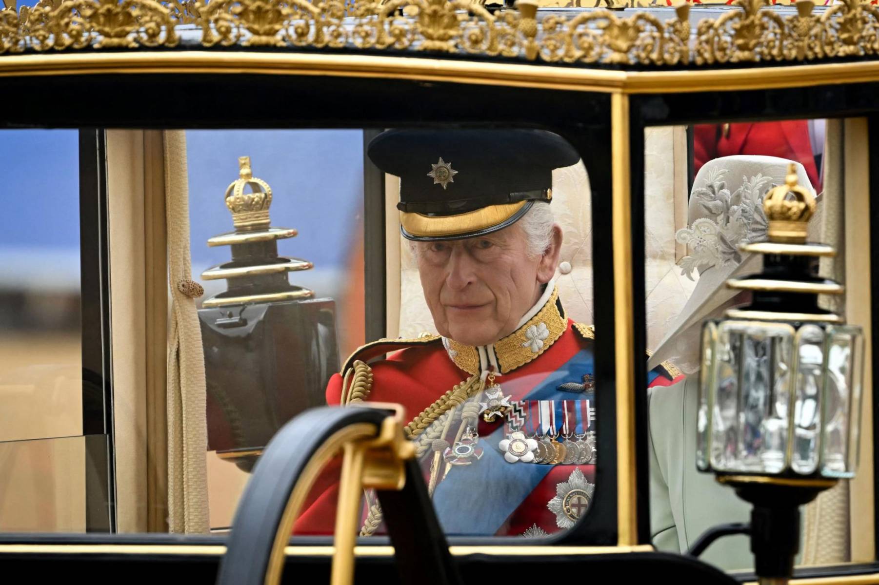 El rey Carlos III se conduce en la carroza rumbo al palacio para saludar a las tropas