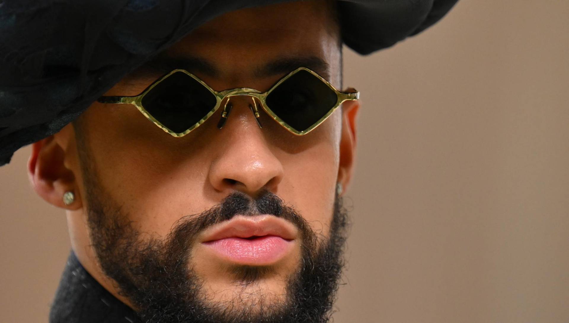 El cantante puertorriqueño llevó unas micro gafas oscuras en forma de rombo (Photo by Angela WEISS / AFP)