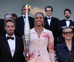 La basquetbolista francesa Iliana Rupert sostiene la antorcha olímpica junto al presidente del comité organizador de los Juegos Olímpicos y Paralímpicos París 2024, Tony Estanguet y la paraciclista francesa Marie Patouillet previo a la proyección de la película<i> Marcello Mio</i> en la 77 edición del Festival de Cannes