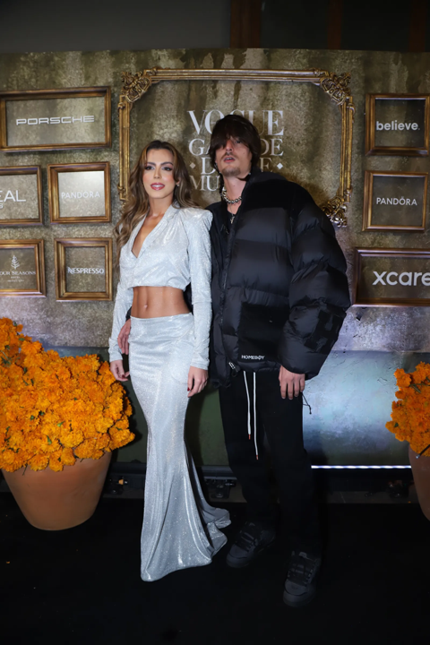 El cantante <b>Danny Ocean</b> y <b>María del Mar</b> lucieron elegantes estilos contrastantes en su paso por la alfombra negra. Danny optó por un atuendo negro oversize, mientras que su novia María deslumbró con un conjunto blanco de la marca mexicana VALCO.