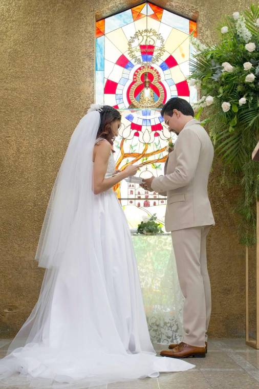 Los novios Ivonne Marie Icaza y David Antonio Valencia al momento de colocar una ofrenda floral a la Virgen de Suyapa.