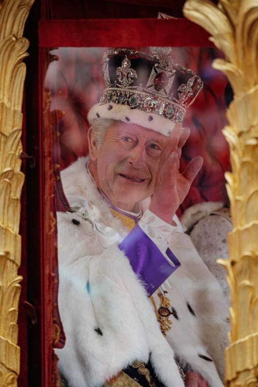 El rey Carlos III saluda al público a bordo de la carroza Gold State Coach minutos después de la coronación en la abadía de Westminster