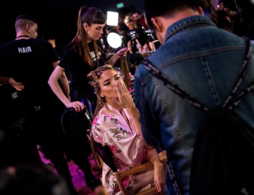 Martha Hunt saluda al fotógrafo mientras se prepara en camerinos