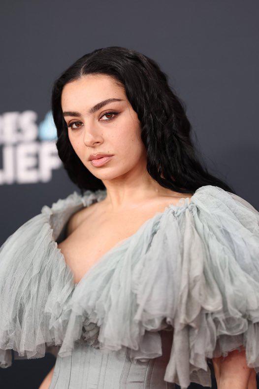 <b>Charli XCX</b> apostó por un look natural y sofisticado. Sus cejas definidas y un suave delineado cat-eye dieron protagonismo a su mirada. Optó por labios nude que complementaron perfectamente su vestido vaporoso, logrando un equilibrio entre lo moderno y lo clásico. 