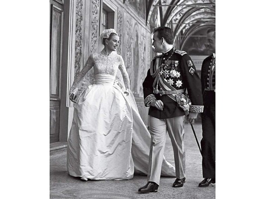 Grace de Mónaco. Cómo olvidar el memorable diseño con que la actriz Grace Kelly desfiló hacia el altar para jurarse amor eterno con el príncipe Rainiero de Mónaco el 19 de abril de 1956. El vestido, diseñado por la ganadora de dos premios Oscar a Mejor Vestuario, Helen Rose, fue un regalo de la Metro-Goldwyn-Mayer a la bella actriz estadounidense que robó el corazón del príncipe. Como si hubiese sido sacado de un cuento de hadas, el ajuar fue elaborado en encaje de Bruselas y tafetán de seda sumado a 90 metros de tul. La parte superior ajustada y la falda plisada de seda se ajustaban a la perfección a la silueta de la novia. Para complementar el look llevó un velo tipo Julieta, una pieza que se une al velo tradicional, permitiendo que éste se deslice por detrás de la cabeza y que se adornó con perlas, brillantes y una corona de flores de cera. las novias más devotas de mediados del siglo XX solían llevar un libro de oraciones en la mano en lugar del típico ramo de flores. El libro era un regalo que le hicieron a la novia y la MGM lo adornó con seda, encajes y perlas. Junto con él, Kelly llevó un pequeño ramo de lirios.