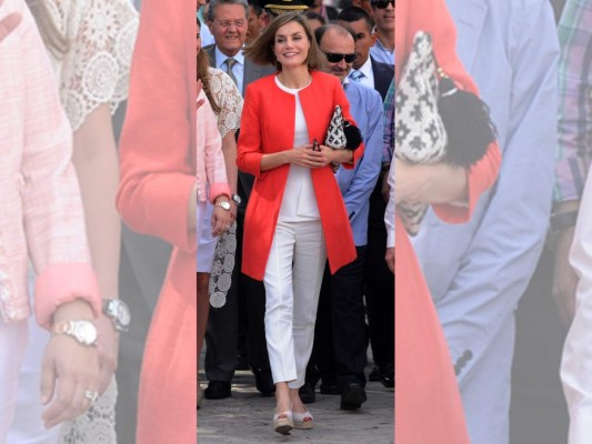 En su visita a Comayagua la reina lució un look mucho más fresco y casual, optando por un conjunto de pantalón slim fit y camisa blanco, ambas de Hugo Boss, un abrido color naranja de Adolfo Domínguez, una cartera de mano clutch étnico de tejido Jacquard de Mango, los aretes de perlas cultivadas en agua dulce, oro blanco de 18 quilates y diamantes de 0,13 quilates de la firma Tous, unas plataformas color crema de marca Castañer y sus lentes de sol Carolina Herrera.