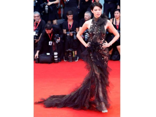 Hikari Mori <br/><br/>La modelo japonesa impactó con una pieza de escote halter con lazada al cuello y larga cola confeccionada en un tejido negro semitransparente decorado con aplicaciones metalizadas, obra de Jaeger-LeCoultre.<br/>