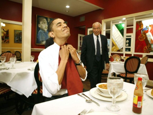Colocando su servilleta en el cuello durante su visita en el restaurante Dooky Chase en Nueva Orleans en 2008