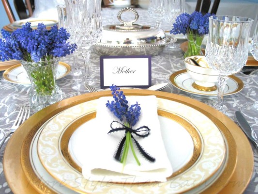 Los tonos metálicos siempre aportan elegancia a la mesa. Combína vajillas en estos tonos y decora cada puesto con un pequeño bouquet en flores de colores contrastantes.Colocar una tarjeta con el nombre de cada comensal siempre será un detalle personalizado que agrada a todos.