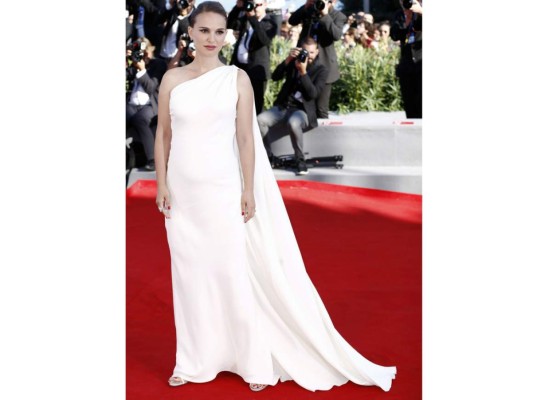 En la reciente edición del Festival de Cine de Venecia con un maxi dress en blanco estilo griego de Dior que revela su estado de embarazo