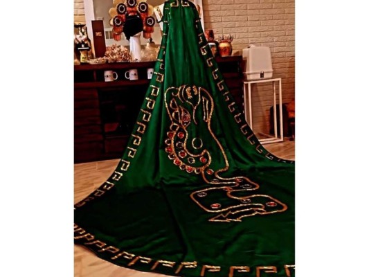El espectacular traje consistía de dos piezas, una larga capa de tres metros y un adorno utilizado en la cabeza, más los detalles en los brazos y tobillos.
