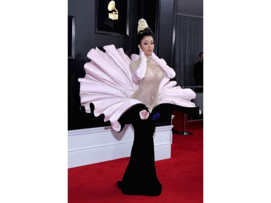 Cardi B<br/>La rapera asistió a los premios Grammy en 2019 con un sorprendente vestido-flor que rápidamente acaparó las miradas de muchos. El conjunto tenía una combinación de tonos rosados con una falda aterciopelada y satinada con unas ondas, haciendo alusión a una corola de flor de donde en el centro nacía Cardi B con un body nude brillante. ¡Parecía una Venus que nacía entre los delicados pétalos de una flor! El vestido vintage salió a la luz en 1995.<br/>