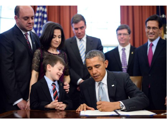 Firmando el Gabriella Miller Kids First Research Act en la Oficina Oval en 2014