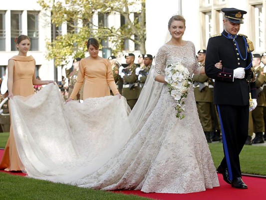 Stéphanie de Lannoy. Guillermo de Luxemburgo se deslumbró ante la belleza de su prometida, quien el 20 de octubre de 2012 desfiló hacia el altar en un hermoso ajuar de doce capas de tul firmado por Elie Saab y elaborado en encaje de color marfil bordado con hilo plateado y manga tres cuartos con encaje. Más de tres mil horas de trabajo, diez costureras y quince bordadoras se necesitaron para confeccionar el vestido de encaje chantilly, calais, organza y crepé de seda con más de 80 mil cristales transparentes y 50 mil cuentas, y que además incluía un velo de tul bordado con hilo de oro de cinco metros de largo. La novia usó una tiara compuesta por 270 brillantes insertados en platino y llevó un bouquet compuesto por orquídeas blancas.