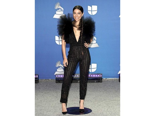 Entre el exceso de ruffles de tul en los hombros, el escote de vértigo, lo ajustado del jumpsuit de rayas, tranparencias y brillo y el peinado, fue difícil apreciar el bello rostro de Debi Nova