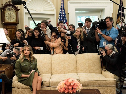 Huraña y distante, Melania nunca intentó disimular que el papel de primera dama no era su favorito. En la imagen de abril de 2017 aparece en la oficina oval, rodeada de la prensa, minutos antes de recibir junto a su esposo Donald Trump al presidente de Argentina, Mauricio Macri (Photo by Brendan Smialowski / AFP)