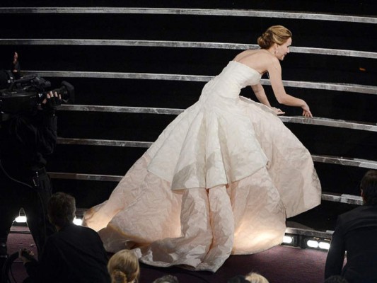 Jennifer Lawrence protagonizó otro momento bochornoso, mientras subía al escenario a recoger su premio se tropezó con su propio vestido de la marca Dior.