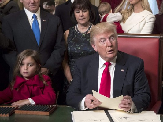 Donald Trump firma documentos relativos a los nombramientos para su equipo rodeado de su vicepresidente, sus hijos y su nieta Arabella