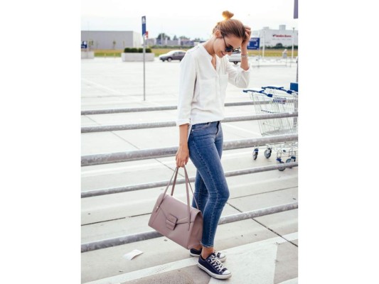 Un casual look con skinny jeans, flow top, bolso XL y un recogido alto sencillo