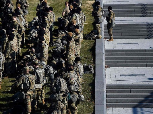 Miembros de la Guardia Nacional toman un breve descanso en las afueras del Capitolio donde Joe Biden será investido como el nuevo presidente de los Estados Unido de América. (Photo by Olivier DOULIERY / AFP)