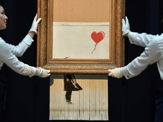 La obra más famosa de Banksy se autodestruye tras ser subastada por más de un millón de euros.