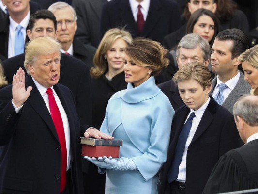 Donald Trump es juramentado como el 45 presidente de Estados Unidos mientras su esposa Melania sostiene las biblias, una es propiedad del nuevo mandatario y fue un regalo de su madre cuando terminó la escuela primaria, en junio de 1955 y la otra Biblia es la que utilizó Lincoln en su primera investidura presidencial, hace 156 años, y que forma parte de la colección de la Biblioteca del Congreso y está encuadernada en terciopelo.