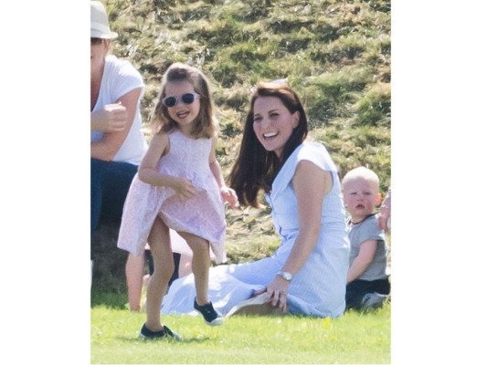 Kate Middleton optó por un vestido azul claro con rayas blancas, muy fresco de marca low cost Zara, perfecto para la ocasión. También utilizó unas alpargatas de cuña de Russell & Bromley.