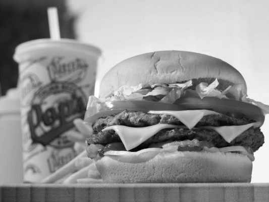 La primera hamburguesa cocinada en América, fue en 1895, por el chef estadounidense Louis Lassen, quien preparó una receta proporcionada por marineros de Hamburgo, Alemania.